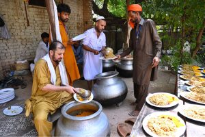 Volunteers serving traditional drinks to people during a rally to celebrate Eid Milad-un-Nabi