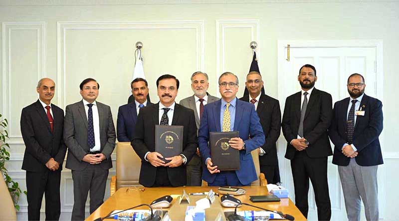 Amjad Majeed Aulakh (DG Operations, NAB) and Jawad Ahmad Dogar (DG, NFA) showing MoU after signing it in the presence of Chairman NAB Lt. Gen (R) Nazir Ahmed and Senior officers of NAB & NFA at NAB Headquarters