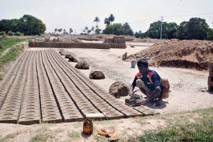 Labourers prepare clay for brick-making at a local brick kiln