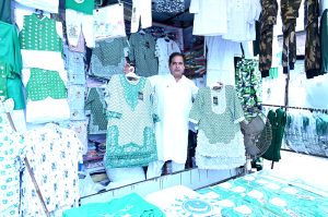 Youngsters purchase festive items from roadside vendor to celebrate Independence Day.