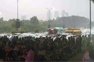 Pedestrians and motorcyclists take shelter under the Srinagar Highway bridge to escape heavy rain in the federal capital