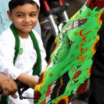 A child on a motorcycle participating in procession on the occasion of Eid Milad-un-Nabi, the birth anniversary of Holy Prophet Muhammad (PBUH)