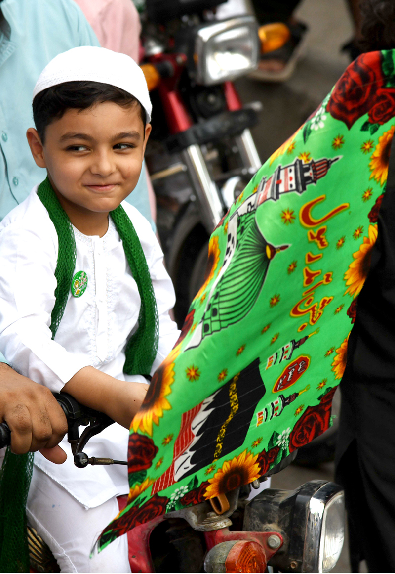 A child on a motorcycle participating in procession on the occasion of Eid Milad-un-Nabi, the birth anniversary of Holy Prophet Muhammad (PBUH)