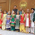Khyber Pakhtunkhwa Governor Faisal Karim Kundi and China Window Administrator Amjad Aziz Malik pose for a group photograph with children after their performance during an Independence Day celebration organized by China Window at Governor House