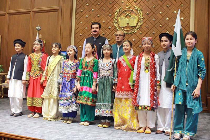 Khyber Pakhtunkhwa Governor Faisal Karim Kundi and China Window Administrator Amjad Aziz Malik pose for a group photograph with children after their performance during an Independence Day celebration organized by China Window at Governor House