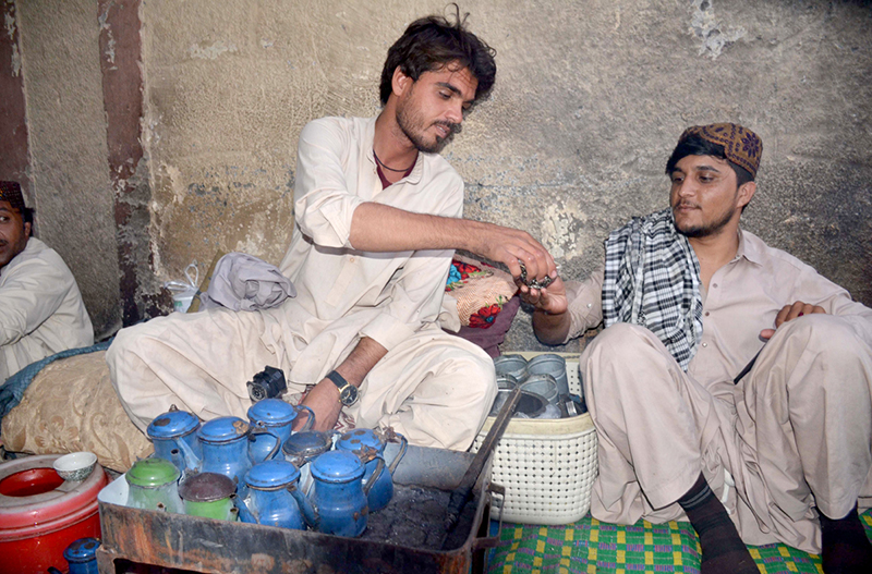 A vendor serves tea to a customer in traditional way at circular Road