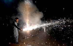 A man holds a firework in his hand during a torchlight procession (Mashal Bardar Jaloos) held on the eve of Eid Milad-un-Nabi (PBUH) to commemorate the birth anniversary of the Holy Prophet (PBUH).