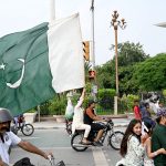 People hold national flag to celebrate the country's Independence Day