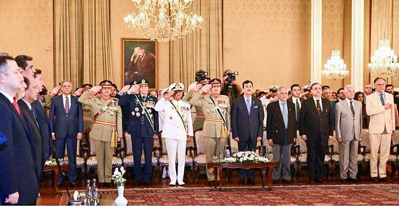 Chairman Senate Syed Yousuf Raza Gilani, Deputy Prime Minister and Foreign Minister Senator Muhammad Ishaq Dar, members of the Federal Cabinet, Chief of Defence Forces Field Marshal Syed Asim Munir, COAS; Chief of the Air Staff, Air Chief Marshal Zaheer Ahmed Baber Sidhu and Chief of the Naval Staff Admiral Naveed Ashraf stand in respect of the National Anthem at a Special Investiture Ceremony held at Aiwan-e-Sadr