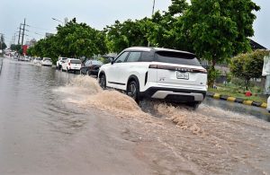 Vehicles wade through rainwater accumulated on PWD Road after heavy rain in the Federal Capital