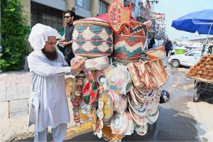 A customer browses through a wide collection of rings, gemstone jewelry and accessories displayed at a roadside stall along Murree Road