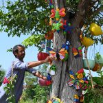 A nursery worker arranges colourful lawn decoration accessories for display and sale while waiting for customers