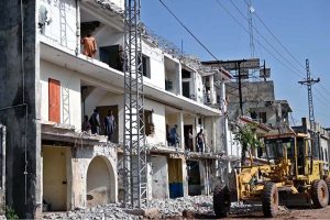 Heavy machinery is being used to demolish illegally constructed plazas built on a road for the expansion of the service road along the Islamabad Expressway
