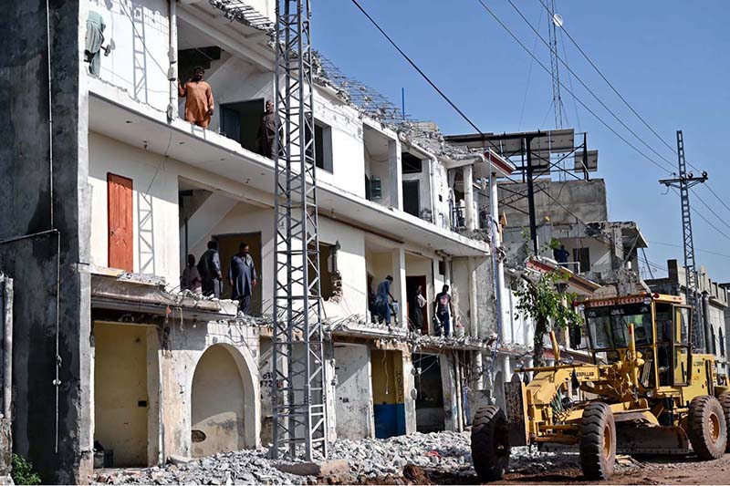 Heavy machinery is being used to demolish illegally constructed plazas built on a road for the expansion of the service road along the Islamabad Expressway