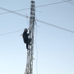 A WAPDA worker busy in fixing electric wires on a pole without proper safety dress or helmet during maintenance work at Zia Masjid