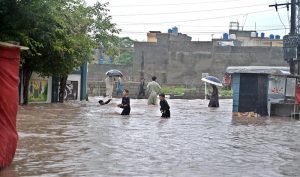 Vehicles move through stagnant rainwater in Ghouri Town following heavy monsoon rainfall in the Federal Capital.