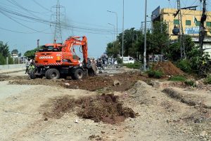 An excavator works on the construction of the service road extension along Expressway near Faizabad interchange.