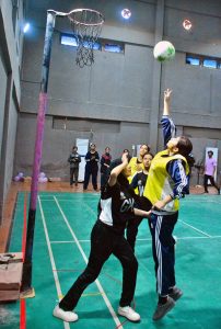 A girls player scores during a netball match between Government Girls High School and Hayat Girls High School at the 5th PNF Netball Cup 2026, held at Hyderabad Club Badminton Hall.