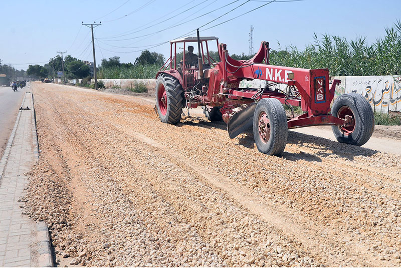 Labourers are busy leveling the ground for road construction as part of development work in Latifabad near a public school