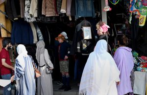 Women purchase used clothes from a vendor at the weekly H-9 Bazaar in the Federal Capital