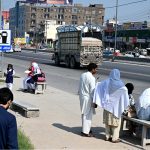 School children waiting for passenger bus at a bus stop on IJP Road as there is no shelter for passengers, need attention of the concerned authorities