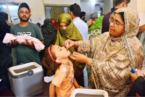 A lady health worker administers polio drops to a child during the anti-polio campaign.