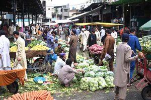 Vendors and customers throng a busy vegetable market, as the supply of fresh produce including cucumbers, tomatoes, carrots and citrus fruits remains active despite heavy monsoon rains lashing the federal capital.