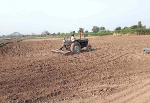 A farmer is busy preparing land for next crop with help of tractor along Lahore Road