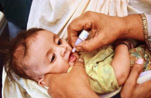 A lady health worker administers polio drops to a child during the anti-polio campaign.