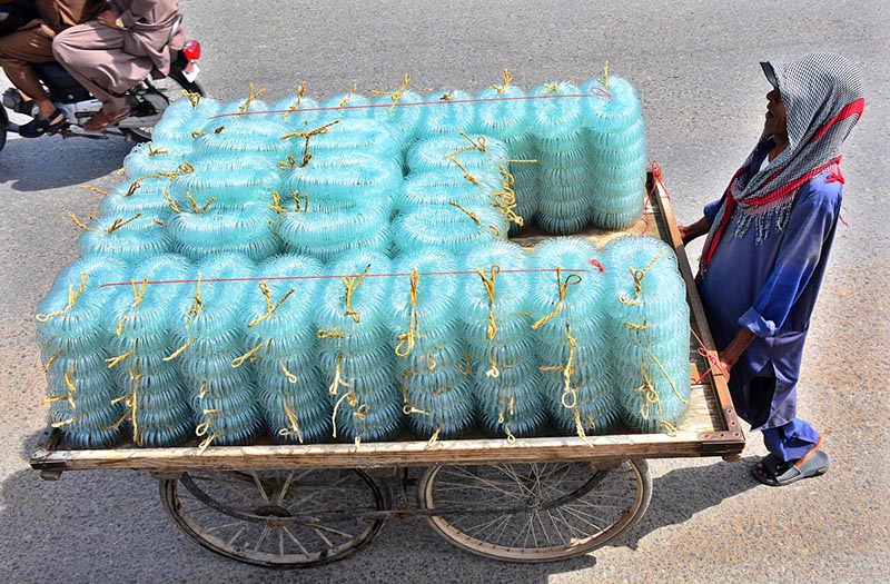 A cart holder on the way, with bangles loaded on the cart to be delivered to the bangles market at Hali Road