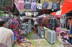 A vendor displays and sells a variety of school bags, luggage bags and other bags at the weekly bazaar in I-9/4.