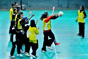 A girls player scores during a netball match between Government Girls High School and Hayat Girls High School at the 5th PNF Netball Cup 2026, held at Hyderabad Club Badminton Hall.