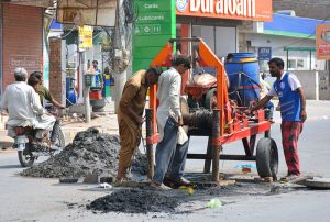 WASA staffers busy clean a sewerage line at Masoom Shah Road.