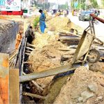 Labourers are busy with the construction work of a sewerage nallah along the road during development work in the city at Latifabad Unit No. 07