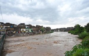 A view of Nullah Leh flowing at a dangerously high level following heavy monsoon rains, as the swollen waterway poses a serious threat to residential areas and settlements built along its banks in the Federal capital.