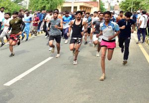 A female student of Government College University Faisalabad (GCUF) crosses the finish line to win the 10-kilometre race during International Sports Day at the university