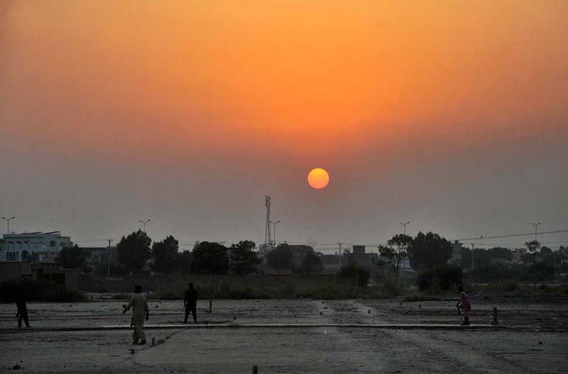 Photo: Youngsters Play Cricket at Sunset in Open Field
