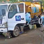 WASA workers are busy removing water accumulated on the road with a suction machine