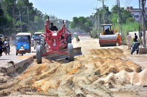 Labourers are busy construction work of new Wahduwah Road with heavy machine during development work in the city.