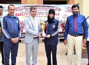 Vice Chancellor of Government College University Faisalabad (GCUF) Prof. Dr. Rauf-i-Azam presents a trophy to the female winner of the 10-kilometre race during International Sports Day at the university