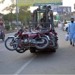 A forklift-mounted traffic lifter hauls away wrongly parked motorcycles as part of an enforcement drive