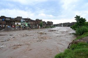 A view of Nullah Leh flowing at a dangerously high level following heavy monsoon rains, as the swollen waterway poses a serious threat to residential areas and settlements built along its banks in the Federal capital.