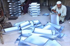 A tray maker preparing metal tray at his workplace.