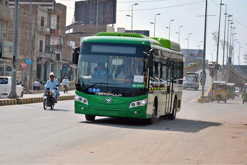 The electric bus in the city moves along a city road, offering commuters modern, eco-friendly, and comfortable public transport with advanced technology