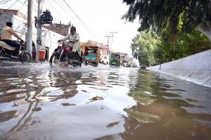 Canal water floods a road in Jinnah Colony following an overflow, disrupting traffic and commuters.