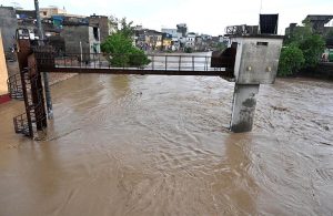 A view of Nullah Leh flowing at a dangerously high level following heavy monsoon rains, as the swollen waterway poses a serious threat to residential areas and settlements built along its banks in the Federal capital.