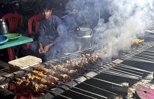 A vendor prepares the traditional food item ‘tikka’ for customers at a roadside stall on Lehtrar Road.