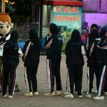 A group of students pose with a mascot at the amusement section of Lake View Park