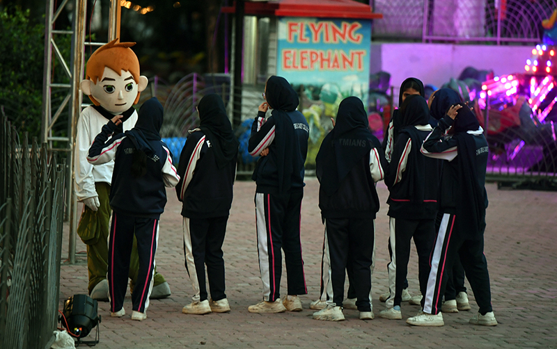 A group of students pose with a mascot at the amusement section of Lake View Park