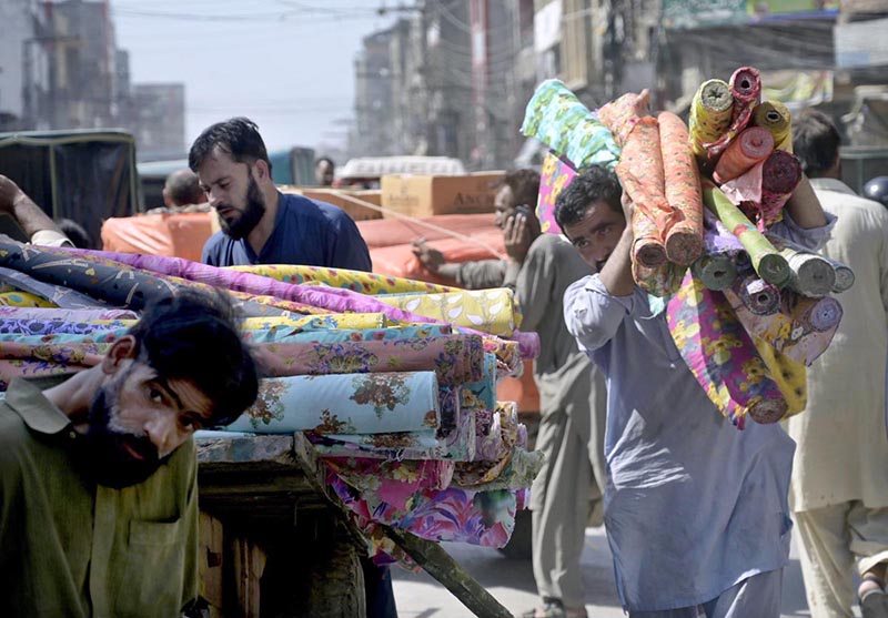 Labourers are busy unloading luggage from a handcart in market at Raja Bazaar